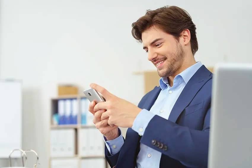 businessman typing on his cell phone