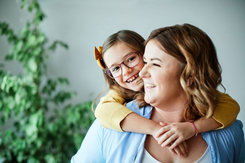 happy mom and daughter smiling and hugging