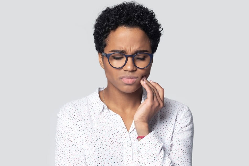 woman holding her jaw in pain