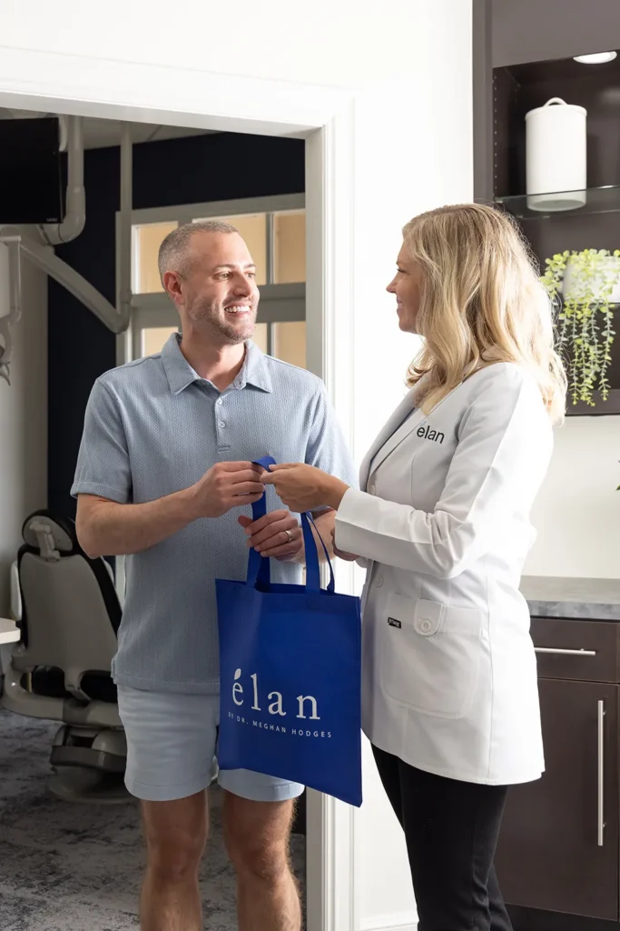 Dr. Meghan Hodges Giving A Patient A Bag At élan