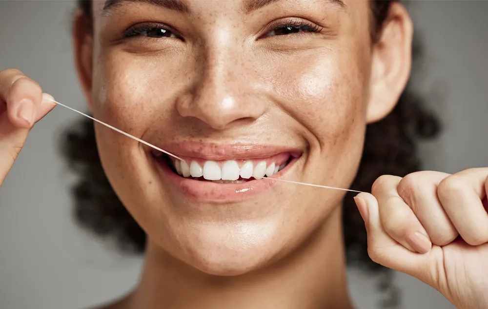 Woman Flossing Her Teeth At élan Tulsa Cosmetic Dentistry In Tulsa, Oklahoma