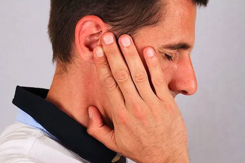 man suffering from ear pain