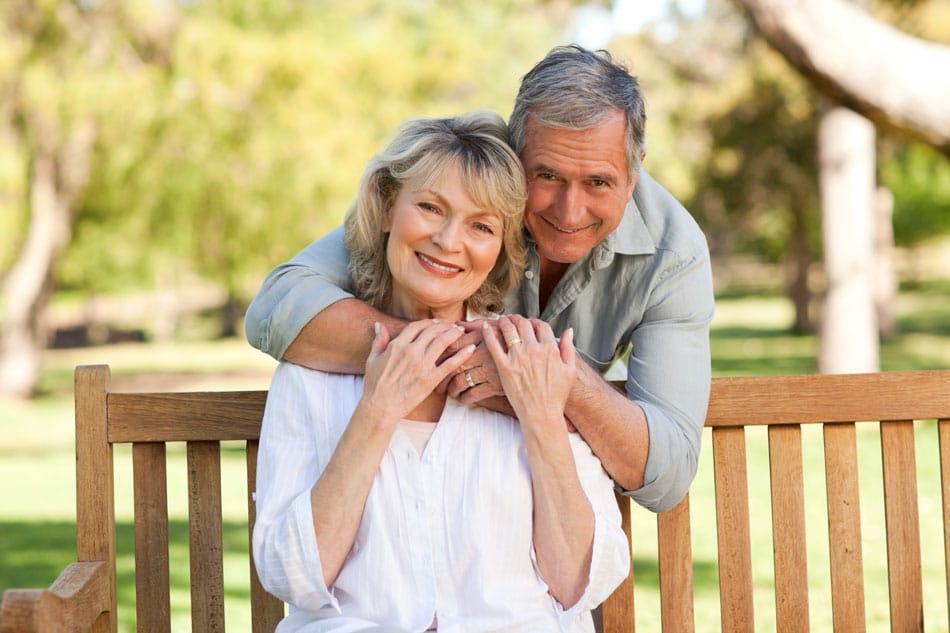 couple embracing sitting on bench outside